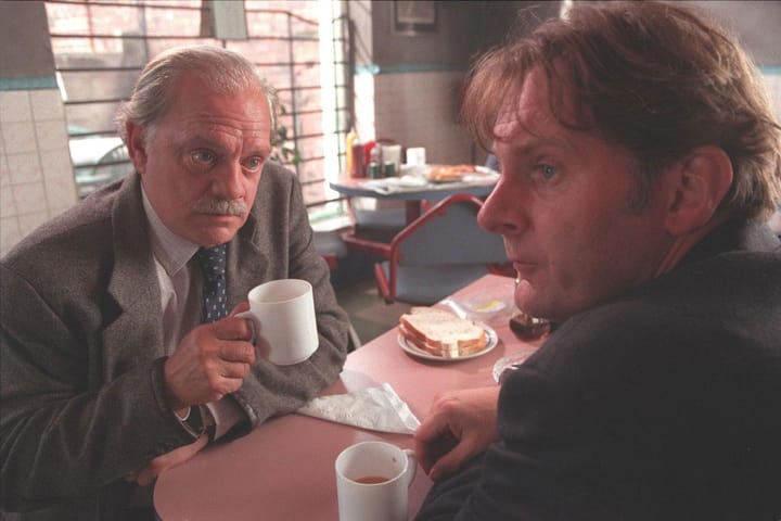 Two detectives drinking tea in a cafeteria